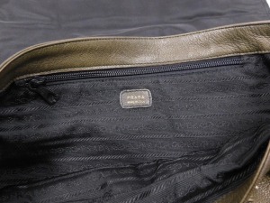 A Prada brown leather shoulder bag, with zipped and open front compartments, bears plaque, 45cm wide. - 4