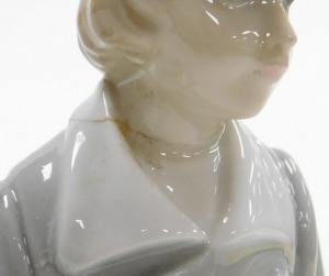 Three Lladro porcelain figures, comprising a boy in a dressing gown with a stool behind, Dutch boy holding two milk pails (AF), and a kneeling figure of a girl. (3) - 3