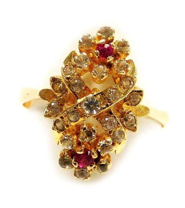 A ruby and white sapphire ring, in a double flower head and cross design, in a yellow metal high claw basket oval mount, stamped 585, size M, 3.1g.