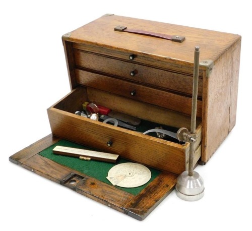 An early 20thC oak tool chest, with a drop down front enclosing four graduated drawers with recess below, holding some tools, 26cm x 41cm x 19cm.