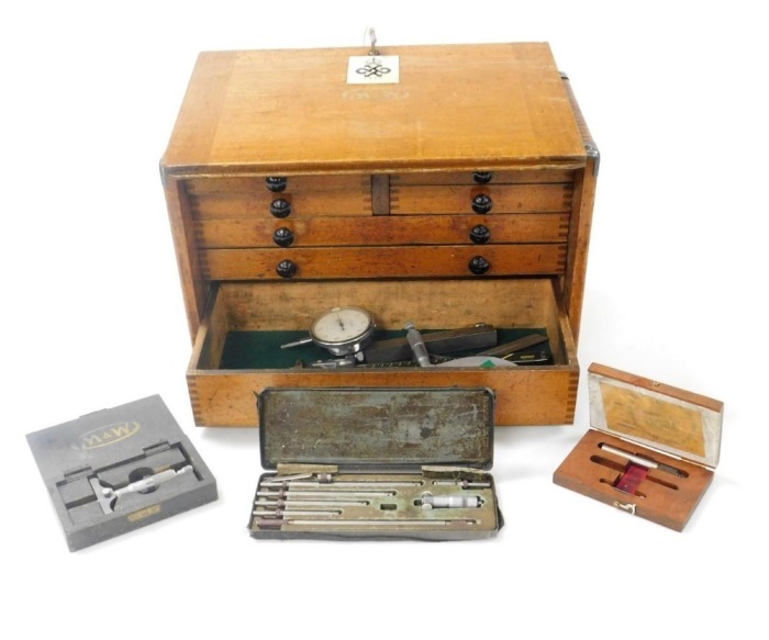 A Moore and Wright oak engineer's chest, the lockable front opening to reveal two short over three long graduated drawers, with a recess below, enclosing assorted tools, with key, 29cm high, 43cm wide, 22cm deep.