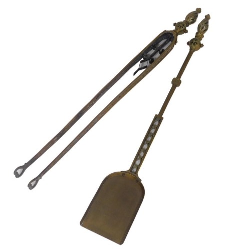 A pair of Victorian brass and copper fireside implements, with pierced decoration, comprising a shovel and pair of tongs, 82cm high.