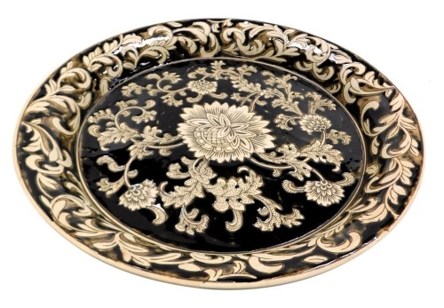 A 20thC brown glazed pedestal bowl, decorated with flowers and leaves within a scroll and foliate border, 39.5cm wide.