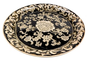 A 20thC brown glazed pedestal bowl, decorated with flowers and leaves within a scroll and foliate border, 39.5cm wide.