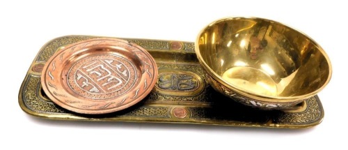 A group of Damascus wares, comprising a brass copper and silver bowl, decorated with reserves of arabesques and foliate scrolls, 12cm wide, a rectangular pen tray, 28cm wide, and a copper dish decorated with arabesques, 10.5cm wide.