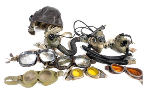 A flying helmet Air Ministry issue, four pairs of flying goggles, one pair of desert goggles, a flying mask and associated tube.