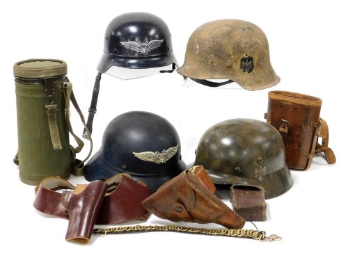 Two German M40 steel helmets and two others, a canteen with webbing case, and various leather items, including binoculars case, holsters and belts.