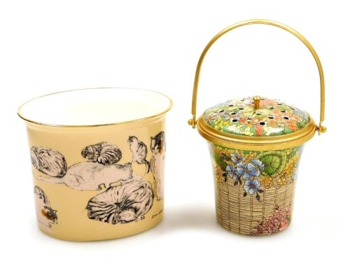 A Halcyon Days enamel pot pourri, modelled as a flower basket, with ring handle, gilt heightened, 8cm high, boxed, together with a porcelain candle holder, decorated with a scene after John Ward, studies of a cat, commissioned by The Royal Academy Of Arts
