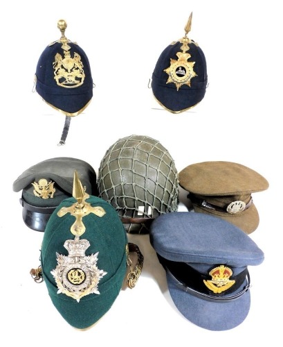 Three British Army helmets, with three regimental badges for the Royal Artillery, South Wales Borders and the Lincolnshire Regiment, one finished in green, two in blue, RAF officer's peak cap, and an officer's peak cap for the Northamptonshire regiment, a