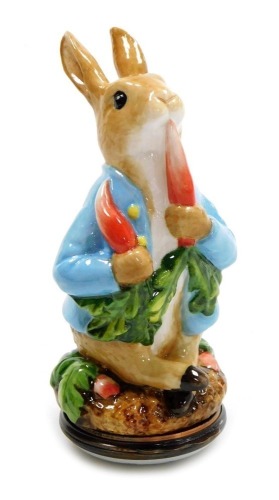 A Halcyon Days porcelain and enamel bonbonniere, modelled as Peter Rabbit eating radishes, 9cm high, boxed.