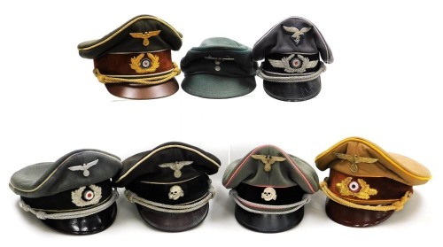 Seven German peaked caps, emblems include Gestapo, Luftwaffe, etc.