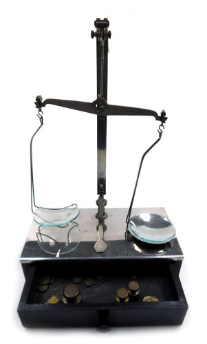 A set of early 20thC W & T Avery Limited balance scales, raised on a metal topped wooden base, with frieze drawer containing the various weights, 25.5cm wide.