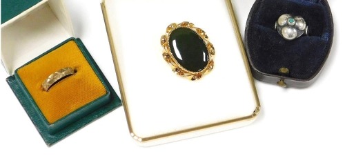 A 9ct gold wedding band, with engraved decoration, size I&frac12;, 1.6g, together with an oval jade brooch in a 14ct plated mount, and a continental silver flower head ring, set with a turquoise. (3)