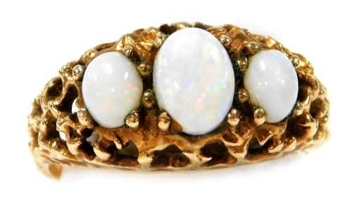 A 9ct gold and opal three stone ring, in a pierced scroll mount, size M, 3.6g.