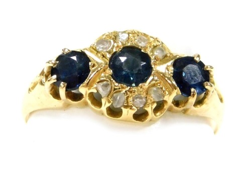 A 18ct gold three stone sapphire and diamond ring, in a claw mount, size N, Chester 1912, 2.19g.