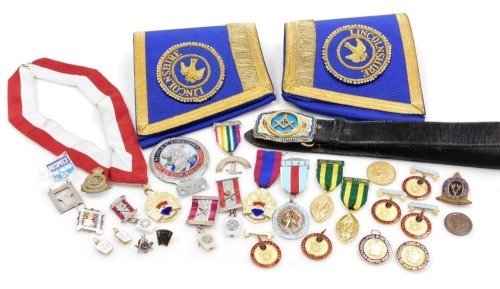 A group of Masonic jewels, belt and a pair of cuffs, together with a Royal Military Academy Sandhurst George VI badge.