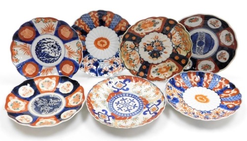 Seven Meiji period Japanese Imari porcelain plates, each of scalloped form, variously decorated, some with transfer printed designs, each 21cm diameter.