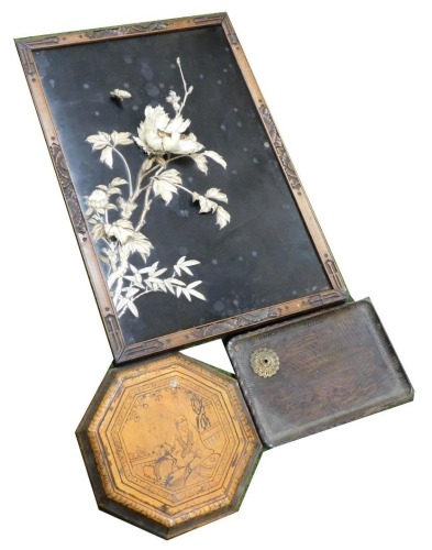 A Meiji period Japanese hardwood and bone shibayama panel, decorated in relief with flowers, leaves and a butterfly, within a carved wooden frame, 64.5cm x 43.5cm, together with an octagonal lacquer lid, and a carved wooden tray. (3)