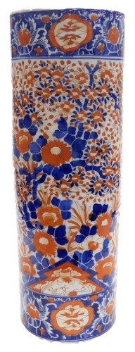 A Meiji period Imari cylindrical umbrella and stick stand, decorated in traditional blue and iron red of flowering shrubs within banded borders, 61.5cm high.