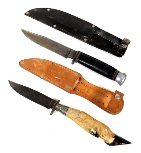 A William Rodgers hunting knife, in a brown leather sheath, together with a further knife with Springbok foot handle, in a tan leather sheath. (2)