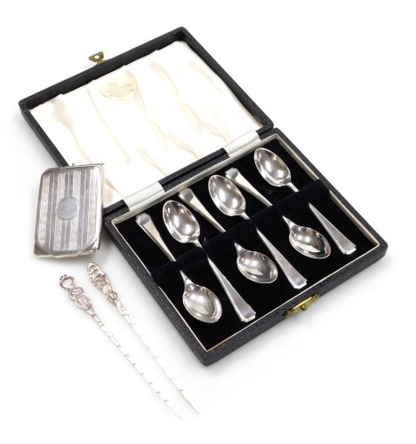 A set of six Elizabeth II silver coffee spoons, cased, Sheffield 1959, together with a George V silver match sleeve, with engine turned decoration, Birmingham 1925, 2.80oz, and two Middle Eastern olive sticks, stamped 800, 0.41oz.