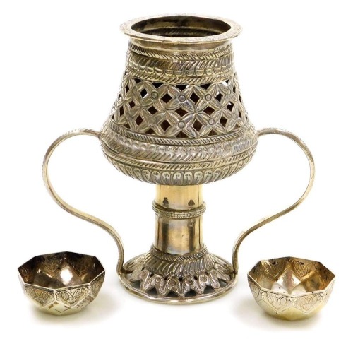 A Middle Eastern incense burner, white metal, of twin handled form, with embossed and pierced floral decoration, 16cm high, together with a pair of Middle Eastern faceted dishes, white metal, 12.28oz all in.