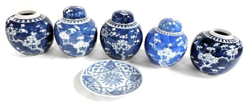 Five Qing Dynasty blue and white ginger jars, three with covers, decorated with prunus blossom against a cracked ice ground, together with a provincial blue and white plate. (6)