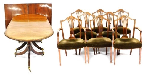 A Georgian style mahogany triple pedestal dining table, with two additional leaves, raised on channelled outswept legs, brass capped, on castors, with an oval glass top, 70cm high, 390cm wide, 107cm deep, together with eight Hepplewhite style mahogany din