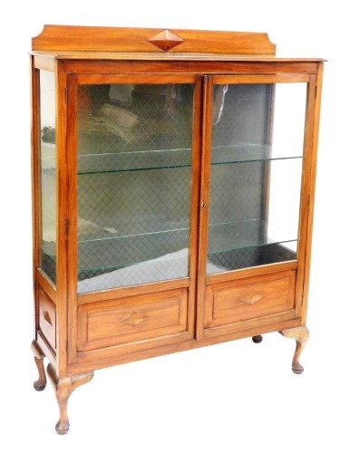 An early 20thC mahogany display cabinet, with a pair of glazed doors enclosing two glass shelves, raised on cabriole legs, 151cm high, 116cm wide, 36cm deep.