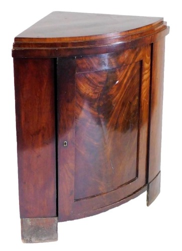 A 19thC Continental flame mahogany bow front corner cupboard, the single door opening to reveal two shelves, raised on bracket feet, 102cm high, 89cm wide, 57cm deep.