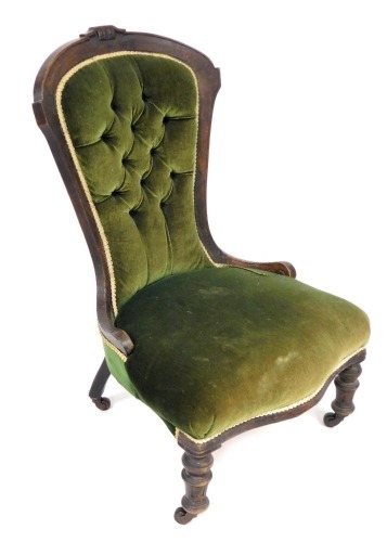 A Victorian mahogany spoon back nursing chair, upholstered in button back green draylon, raised on turned legs.