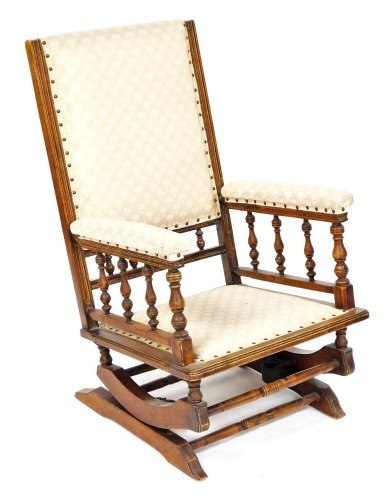 A late 19thC American walnut frame rocking chair, upholstered in patterned fabric, 59cm wide.