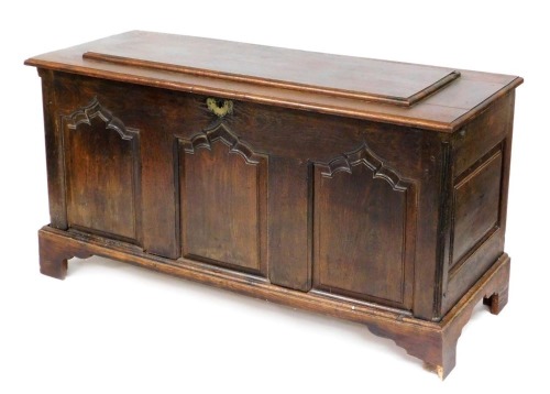 An 18thC and later oak coffer, with a hinged lid, triple panel front, raised on bracket feet, 81cm high, 151cm wide, 60cm deep.
