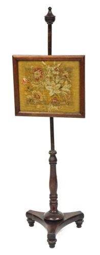 A late Regency mahogany pole screen, the rectangular screen with floral tapestry, raised on a turned column over a trefoil base, on turned feet, 138cm high.