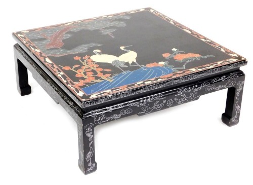 A Chinese square black lacquer coffee table, painted with cranes, trees, and flowers, raised on square legs, 38cm high, 90cm wide, 90cm deep.