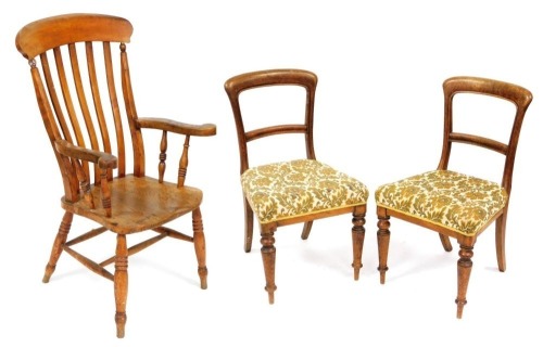 A Victorian beech and elm lath back kitchen chair, with solid saddle seat, raised on turned legs united by an H frame stretcher, 62cm wide, together with a pair of Victorian oak single dining chairs, with overstuffed seats, raised on turned legs. (3)
