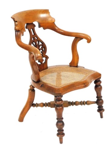 A Victorian mahogany armchair, with a foliate carved vase shaped splat, cane seat, raised on turned legs united by a turned X frame stretcher, 61cm wide.