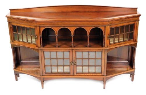 A Victorian mahogany side cabinet, the curved pedimented back over a four arch recess, raised on turned columns, flanked by two glazed cupboard doors, over a pair of central glazed doors flanked by recesses raised on square tapering legs, label for Libert