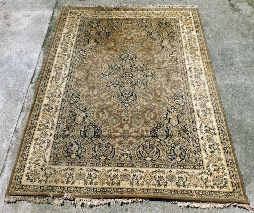 A Persian style brown ground rug, decorated with a central medallion with flowers and botehs, within a ground of further flowers, leaves and botehs, within repeating floral borders, 355cm x 275cm.