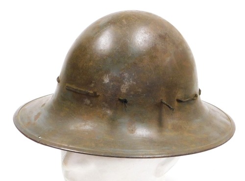 A WWII British Home Front steel helmet, dated 1941 with maker's mark JSS and M, with original lining.