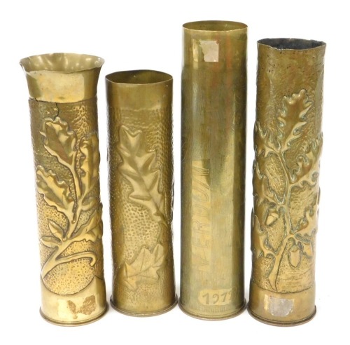 Four WWI brass ordnance shell cases, all with trench art decoration, including one inscribed Verdun, 1917, and three with embossed and hammered foliage decoration, the tallest 35cm.