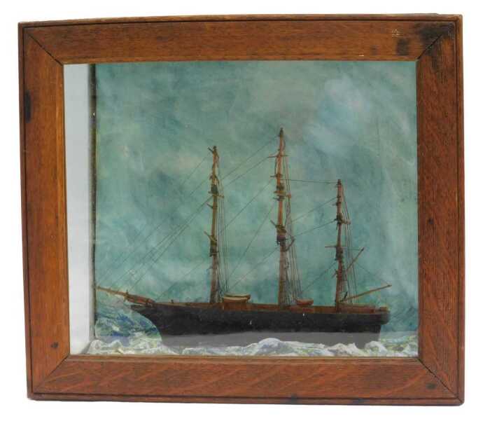 A 19thC model of a tea clipper, on painted waves, contained in an oak and glass case, 32cm x 36.5cm.