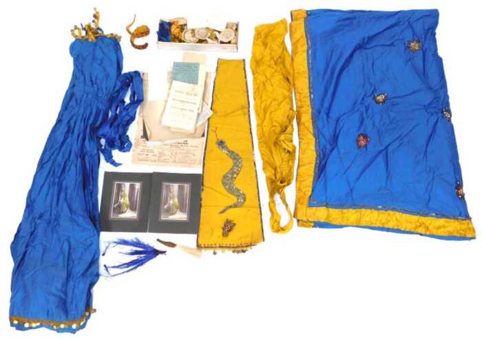 An early 20thC Middle Eastern costume, in blue and yellow, comprising a top, a skirt and front panel depicting snake in sequins, with coin embellishment, together with a fabric and stone set snake arm bangle, various accoutrements, etc., together with two