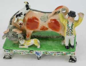 An early 19thC Staffordshire pottery figure group, titled Bull Beating Now Captain Lad, 14cm high. (AF) - 2