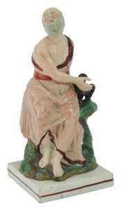 An early 19thC Staffordshire figure, modelled as Elijah and the Raven, 25cm high.
