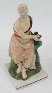 An early 19thC Staffordshire figure, modelled as Elijah and the Raven, 25cm high. - 2