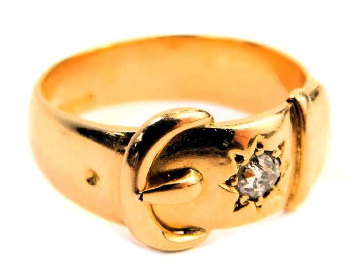 A Victorian 18ct gold buckle ring, the raised buckle design inset with round brilliant cut diamond, star set, approx 0.25ct, Birmingham 1888, ring size V&frac12;, 10.7g all in.