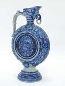 A Westerwald salt glazed jug, on a blue and grey patterned ground, with shield, 29cm high. - 2