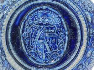 A Westerwald salt glazed jug, on a blue and grey patterned ground, with shield, 29cm high. - 5