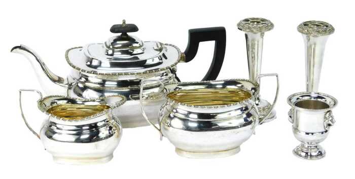 A silver plated three piece tea set, comprising teapot, milk jug, sugar bowl, each with a beaded border and ebonised handle, a pair of silver plated stem vases and a miniature Campana urn. (6)